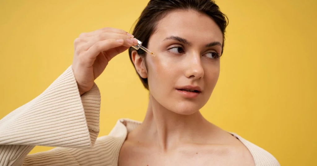 a beautiful lady is applying something with dropper 
