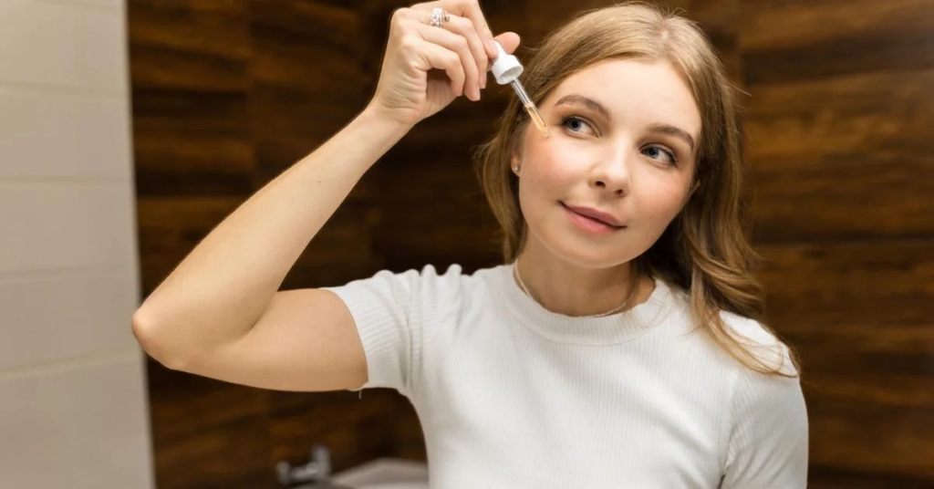 A beautiful lady is applying serium on her face